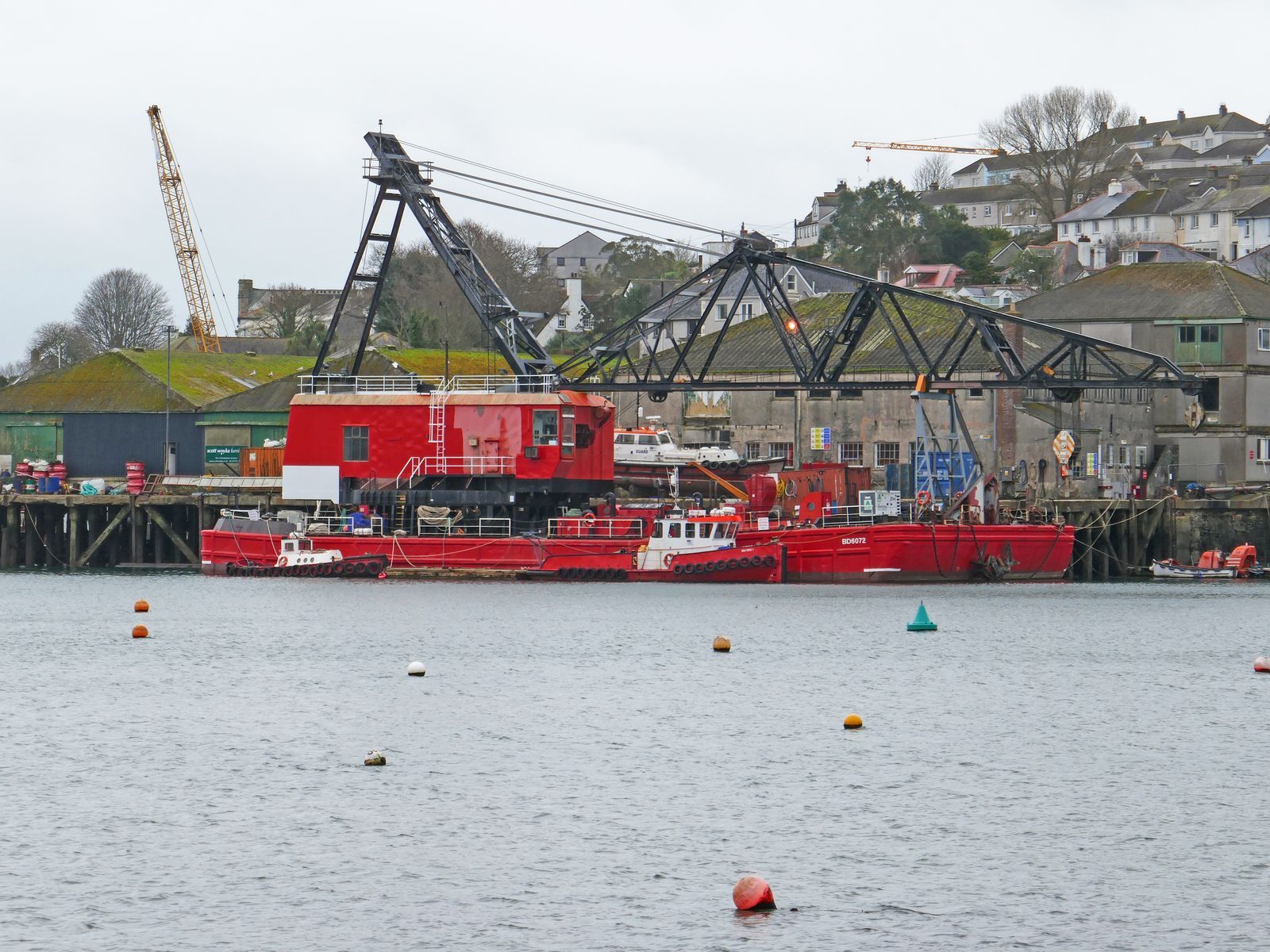 Heavy-lift vessel with onboard cranes in harbour